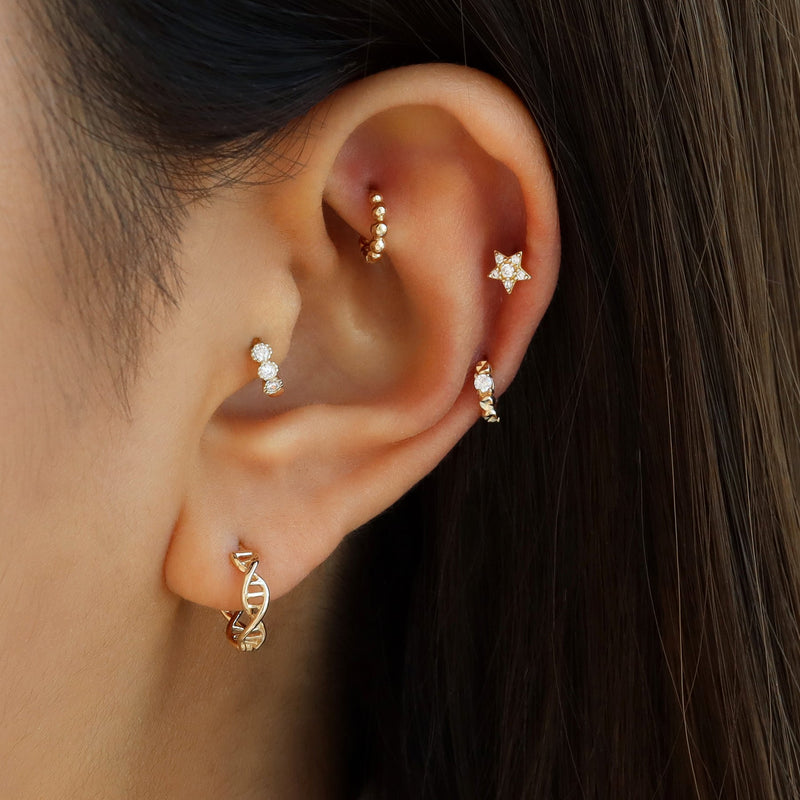 triple gem huggie hoop earring in tragus piercing