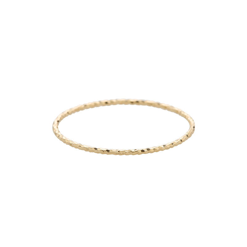 a thin textured stacking ring made from 14k gold