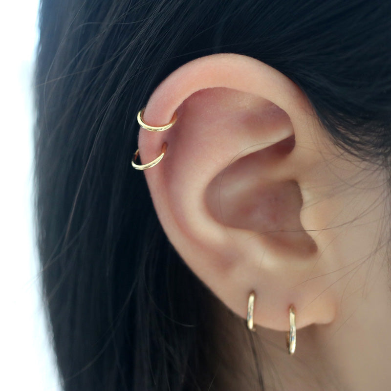 stacked clicker segment rings in cartilage helix and lobe piercings
