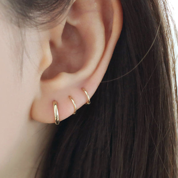 Stacked triple lobe piercings with 14k gold huggie hoops