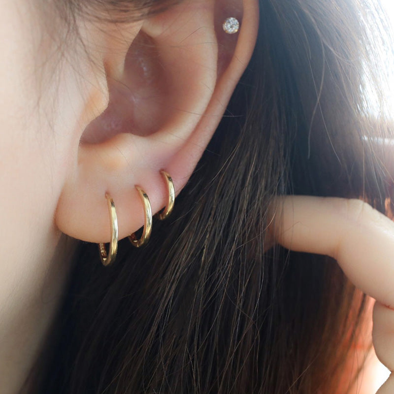 slim hoop earrings in stacked triple lobe piercing and made in solid 14k gold
