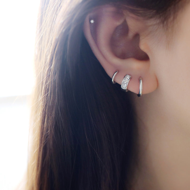 tiny stacking huggie hoops in third, second and first hole piercing