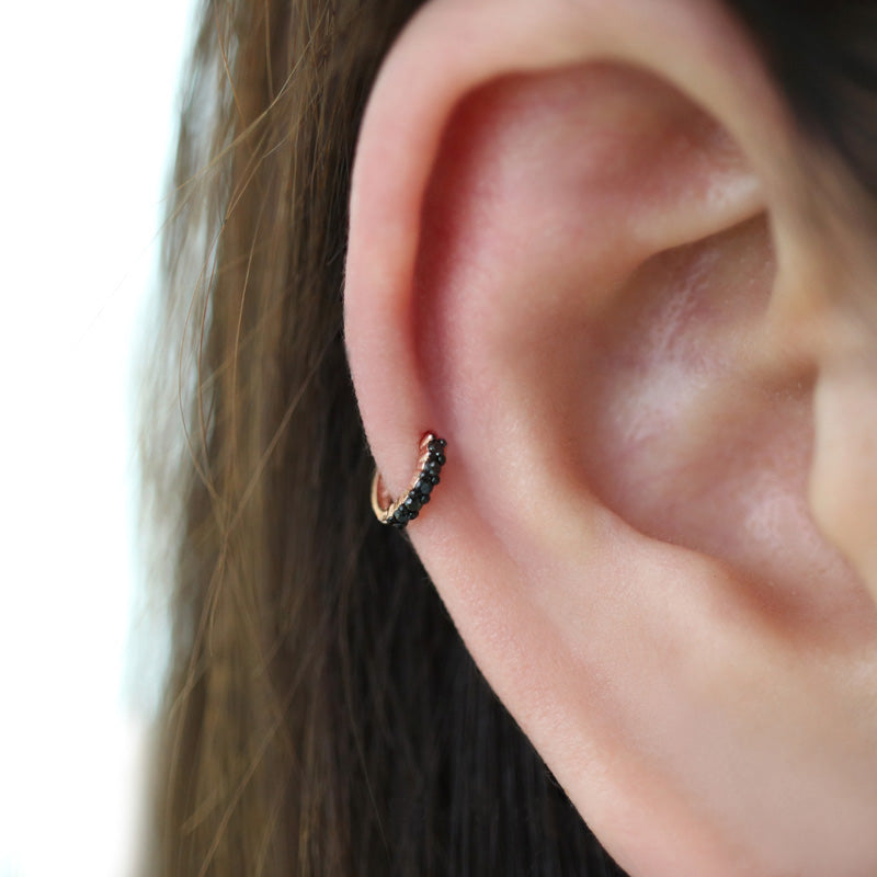 black huggie hoop earring in cartilage piercing