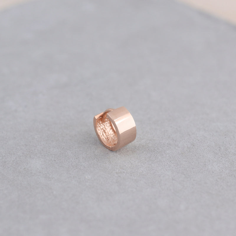 small wide huggie hoop made from 14k rose gold